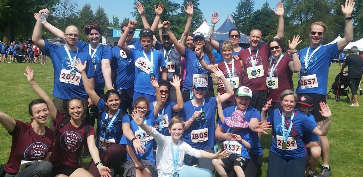team photo of OT Works! employees cheering after race